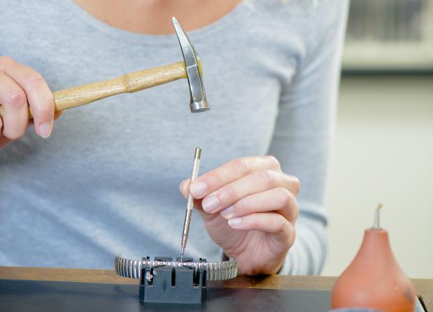 Frau benutzt Werkzeug für Armbanduhranpassung