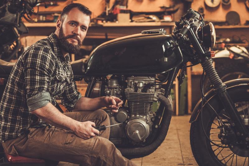 Ein Mann schraubt an einem schweren Vintage-Motorrad Breitling Zorro