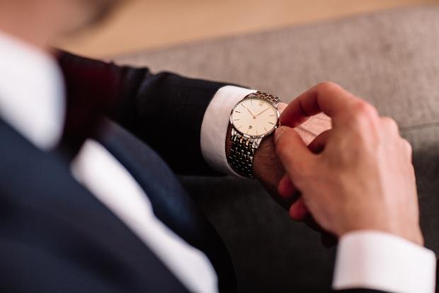 Mann stellt seine Armbanduhr ein - Mechanische Uhr einstellen