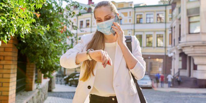 Frau schaut während Pandemie auf Armbanduhr