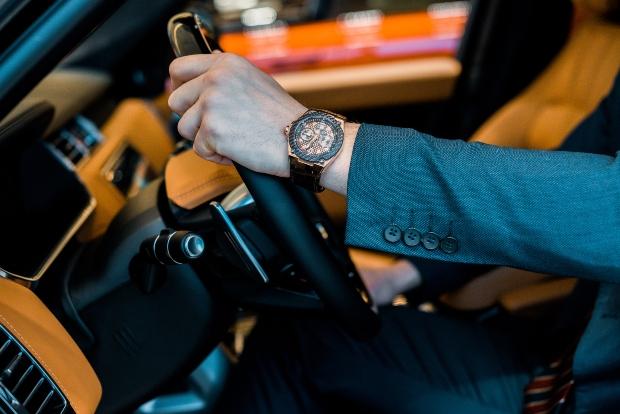 Geschäftsmann mit Armbanduhr in einem Luxusauto - Luxusuhren trotzen der Corona Pandemie