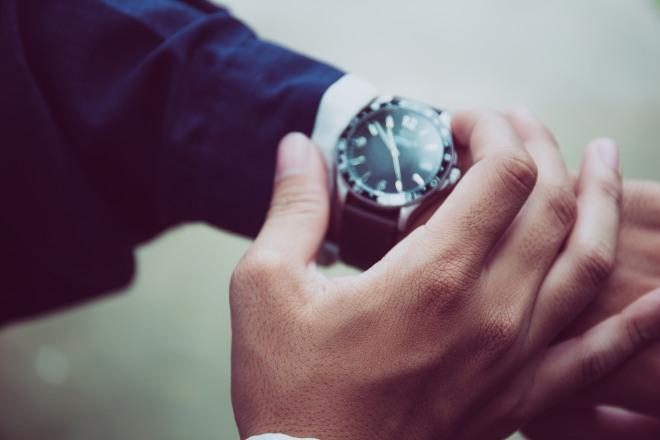 A man looks at his luxury watch on his wrist