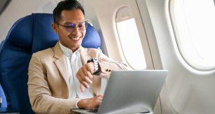 Mann-im-Flugzeug-schaut-auf-Armbanduhr - Luxusuhren bis 2000 Euro