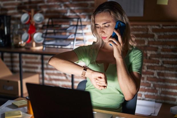 Junge-Frau-im-Home-Office-mit-Armbanduhr